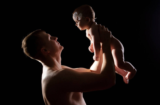 Hombre sosteniendo agradable bebé niña. Nuevo concepto de vida. Hija en brazos de los padres
 - Foto, Imagen