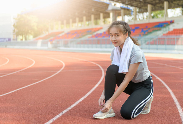 Atleta asiático menina tentando tênis de corrida se preparando para correr na pista, esporte e conceito saudável
 - Foto, Imagem