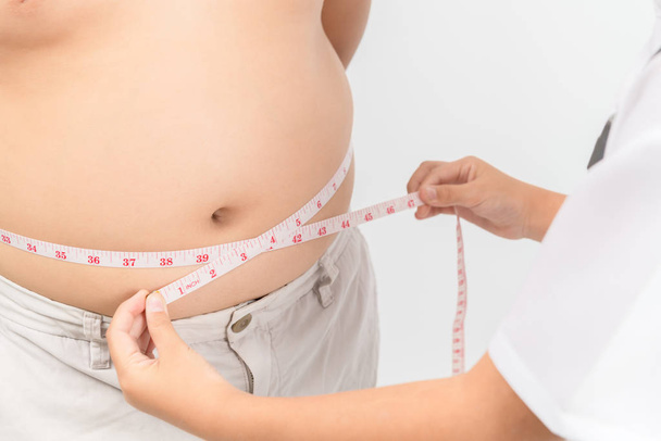 Pieni lääkäri mittaamalla lihavia lapsi vyötärö kehon rasvaa eristetty
 - Valokuva, kuva