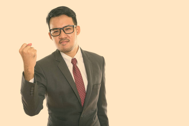 Studio shot of young Asian businessman looking motivated - Φωτογραφία, εικόνα
