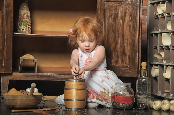 rudowłosy dziewczyna siedzi gra w vintage kuchnia - Zdjęcie, obraz