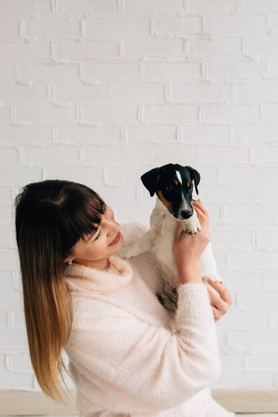 The owner and pet, the girl holds the Russell Terrier, the view from the side, close-up on a white background - Fotoğraf, Görsel