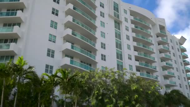 Mavi gökyüzünde palmiye ağaçları olan apartman binası - Video, Çekim
