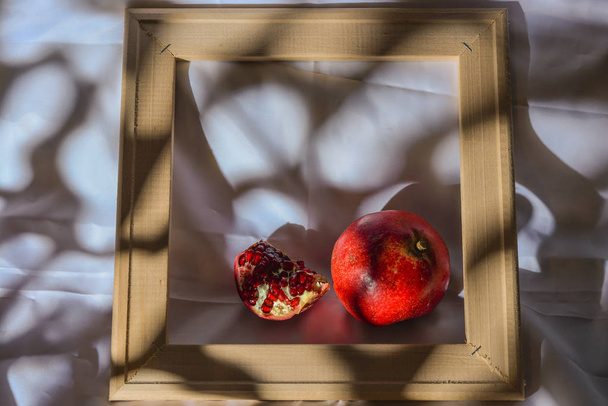 pomegranate in frame on background - Foto, afbeelding