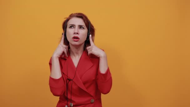 Pettynyt nainen, jolla on mukavat kuulokkeet, osoittaa sormella sitä, kuunnella musiikkia
 - Materiaali, video