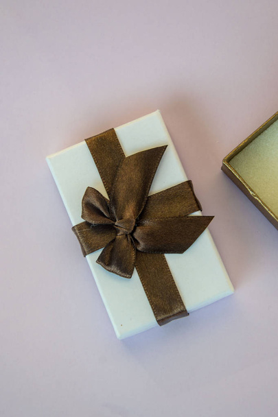 Крупним планом відкрита коробка зі стрічкою, подарунок на свята, фіолетовий фон
 - Фото, зображення