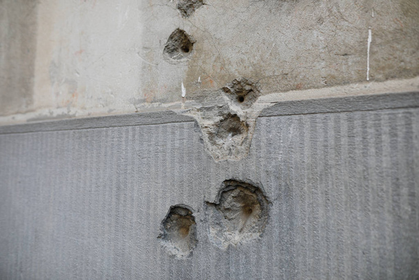 Részletek golyó ütötte lyukakkal a falon a román anti-vesszőből. - Fotó, kép