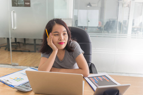 Офісна жінка тримає олівець і думає про бізнес-плани в офісній компанії
 - Фото, зображення