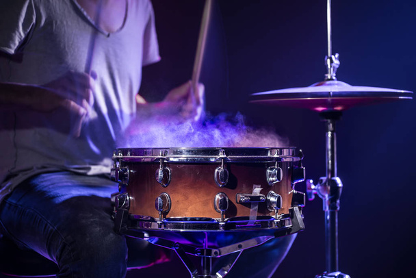 A drummer plays drums on a blue background. Beautiful special ef - Fotó, kép