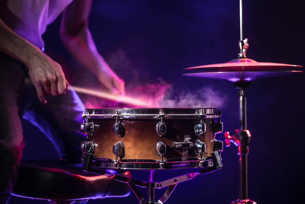 The drummer plays the drums. Beautiful blue and red background,  - Photo, Image