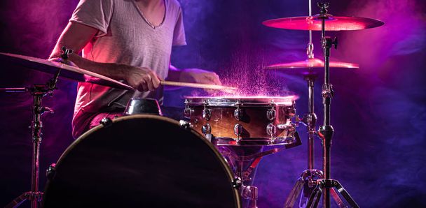 der Schlagzeuger spielt Schlagzeug. schöner blauer und roter Hintergrund,  - Foto, Bild