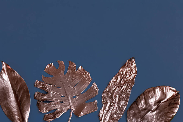 El fondo está pintado con hojas de color dorado sobre una ba azul
 - Foto, imagen