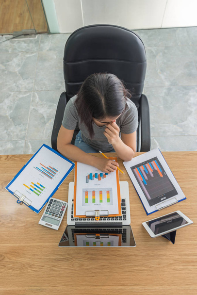 Asian businesswoman working under high pressure on financial reports - Foto, Bild