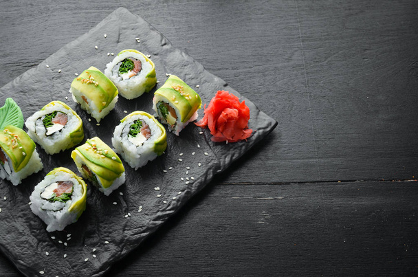 Sushi roll with avocado, salmon and onion. Free space for your text. Japanese Traditional Cuisine. Top view. Rustic style. - Фото, зображення