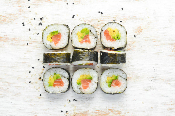 Sushi maki with salmon, avocado and nori. Free space for your text. Japanese Traditional Cuisine. Top view. Rustic style. - Foto, immagini