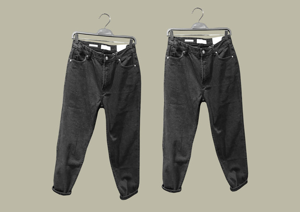 Комплект черных джинсов с карманами на вешалке изолирован на коричневом фоне. Джинсы вид спереди сверху. Коллаж модной одежды. Трендовый коллаж одежды. Джинсы. Концепция моды - Фото, изображение