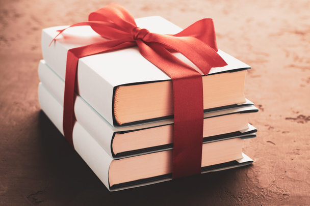 A stack of three books tied with a ribbon: the concept of a good book is a good gift - Photo, Image
