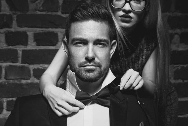 Vrouw das strik voor sexy man in smoking zwart en wit - Foto, afbeelding