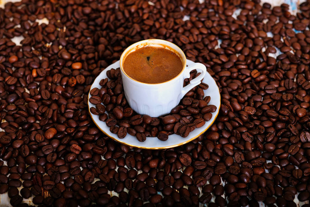 Top View Foto, Geroosterde bruine koffiebonen en hete koffie, latte art op rustieke tafel.  - Foto, afbeelding