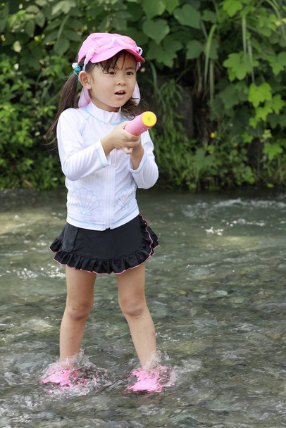 Japans meisje spelen in de rivier met waterpistool (4 jaar oud) - Foto, afbeelding