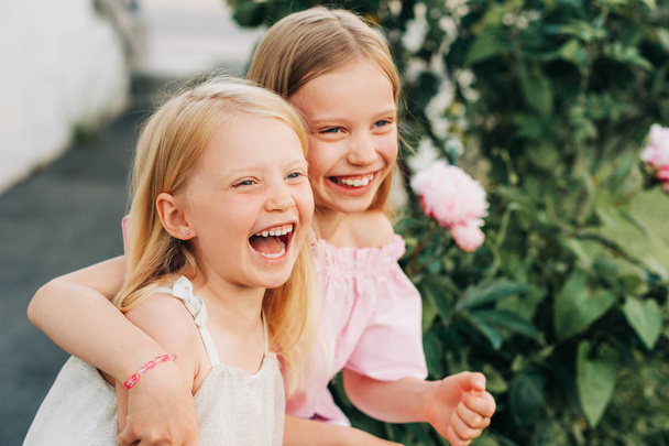 Portrait extérieur de deux petites filles douces, enfants jouant ensemble dans le jardin d'été
 - Photo, image