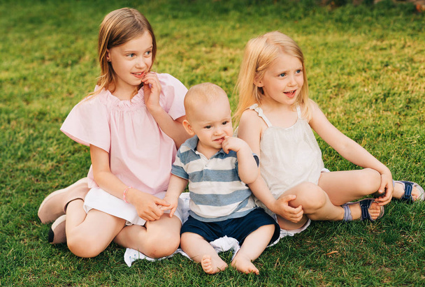 Mädchen spielen entzückenden kleinen Bruder im Sommerpark - Foto, Bild