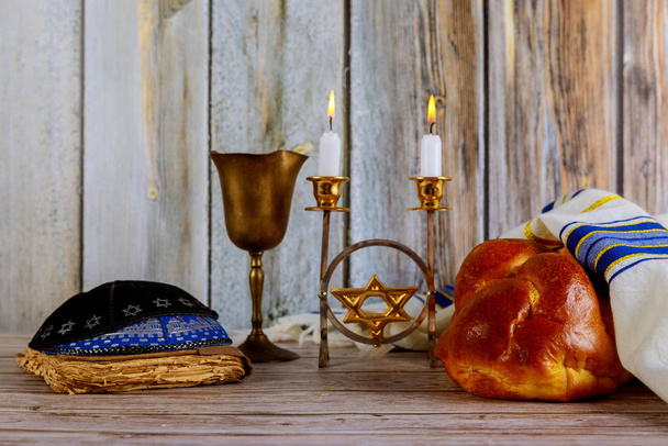 Shabbat mit Challah-Brot auf einem Holztisch Kerzen und eine Tasse Wein. - Foto, Bild