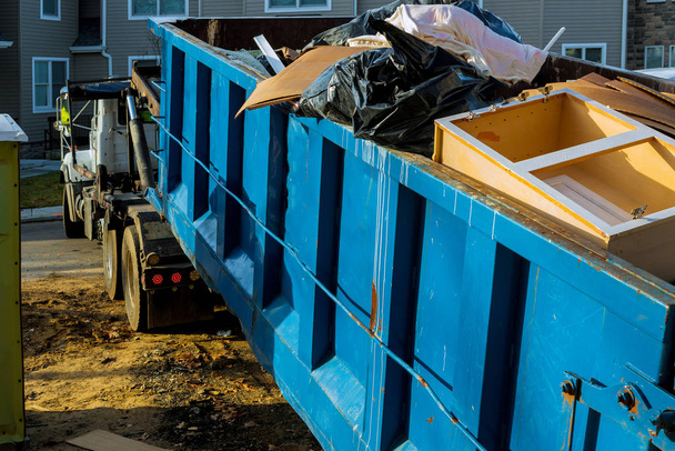 Roskikset, kierrätysjätteet ja roskakorit kerrostalojen rakennustyömaan lähellä
 - Valokuva, kuva