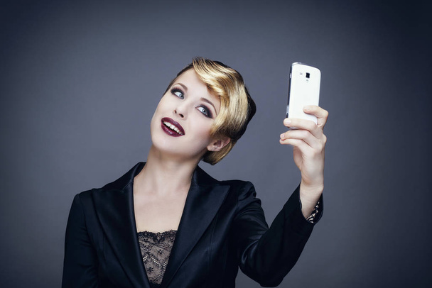 Portrait of a young woman in taking a photo with her mobile phone - Foto, Imagem