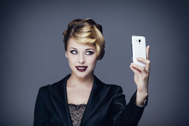 Portrét mladé ženy při focení se svým mobilním telefonem - Fotografie, Obrázek