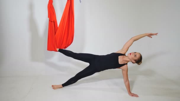 Fly yoga ion sfondo bianco. Stile di vita e sport. Yong donna sportiva esegue esercizi fisici per lo yoga dell'aria, pilates, salute ristoratrice. Girato in 4k
 - Filmati, video