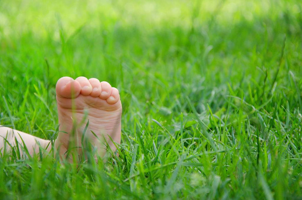 Baby blote voet in het gras.  - Foto, afbeelding