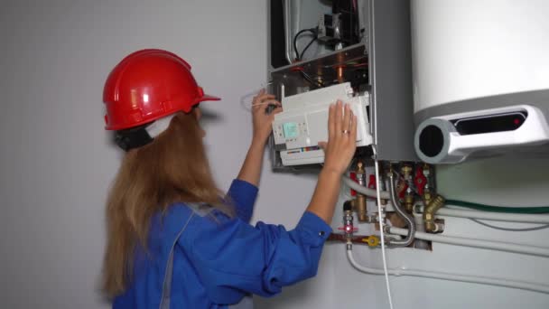 Professional worker girl servicing the gas boiler for hot water and heating - Footage, Video
