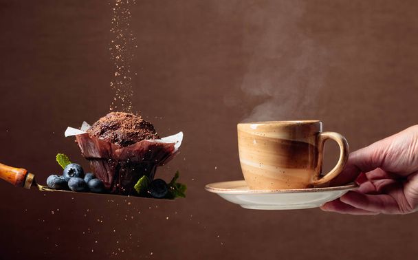 Magdalena de chocolate con arándanos y menta espolvoreada con chocol
 - Foto, imagen