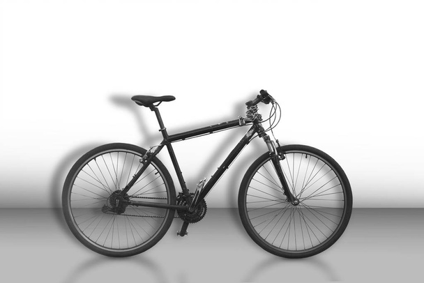 Bicicleta negra sobre fondo monocromo escaso
 - Foto, imagen