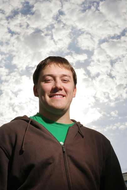 zelfverzekerde jonge man over hemel - Foto, afbeelding