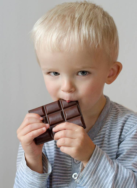 Маленький хлопчик дегустує шоколад. Дитяча концепція
. - Фото, зображення
