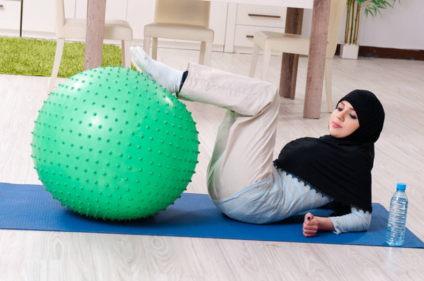Young woman in hijab doing exercises at home - Photo, Image
