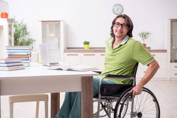 Joven estudiante masculino en silla de ruedas en casa - Foto, Imagen