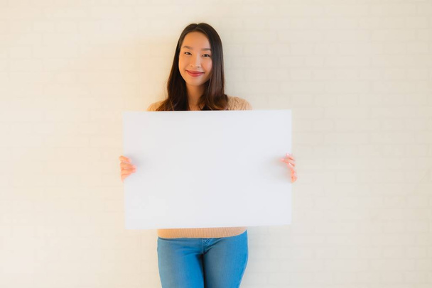 Portré gyönyörű fiatal ázsiai nők mutatják üres fehér papír vaddisznó - Fotó, kép