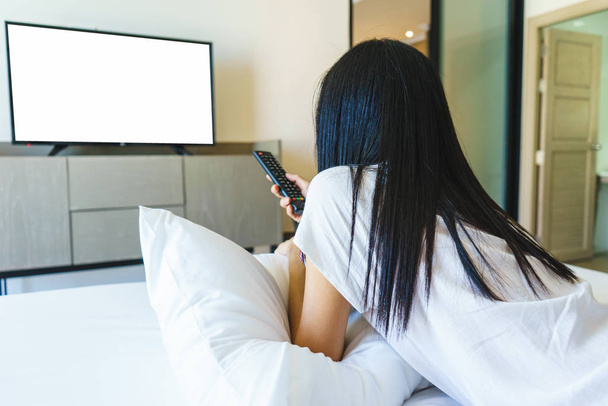 Asia woman relax on bed and watching television - Zdjęcie, obraz