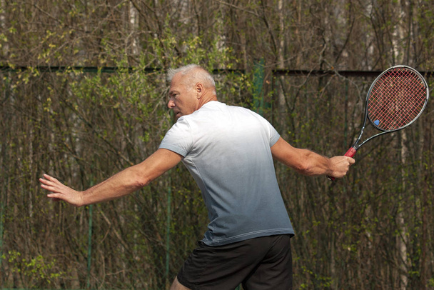 Man playing tennis on the outdoor court - Zdjęcie, obraz