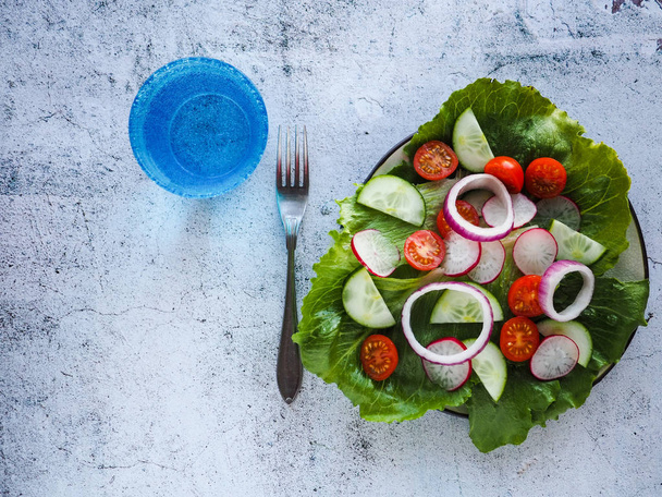 Fresh vegetarian salad and a glass of water. Healthy lifestyle. - Photo, Image