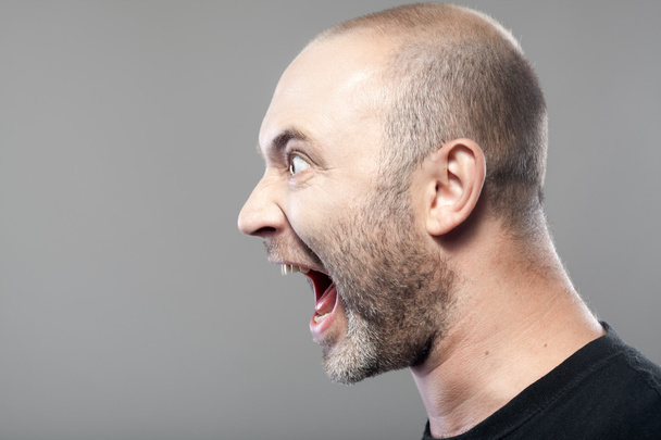 Portrait of angry man screaming isolated on gray background with - Foto, afbeelding