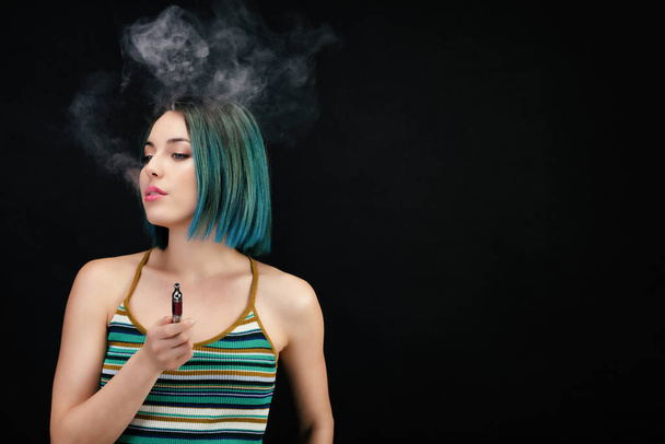 Young woman vape an electronic cigarette - Foto, Imagem