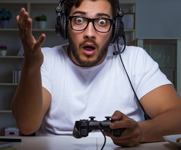 Молодой человек играет в игры долгие часы в офисе - Фото, изображение