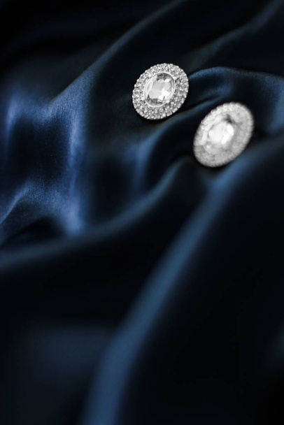 Luxury diamond earrings on dark blue silk background, holiday gl - Photo, Image