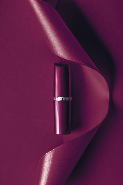Luxury lipstick and silk ribbon on plum holiday background, make - Photo, Image