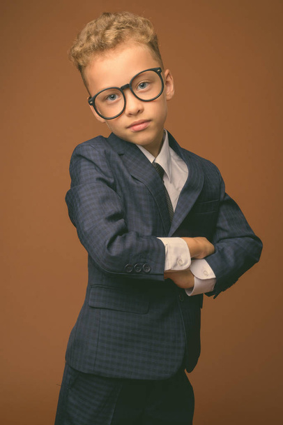 Giovane ragazzo come uomo d'affari contro sfondo marrone
 - Foto, immagini