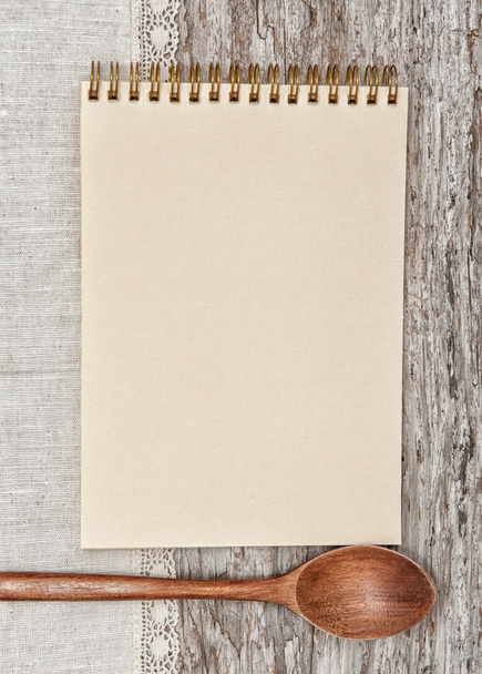 Бумажная тетрадь, деревянная ложка и льняная ткань на старом дереве
 - Фото, изображение